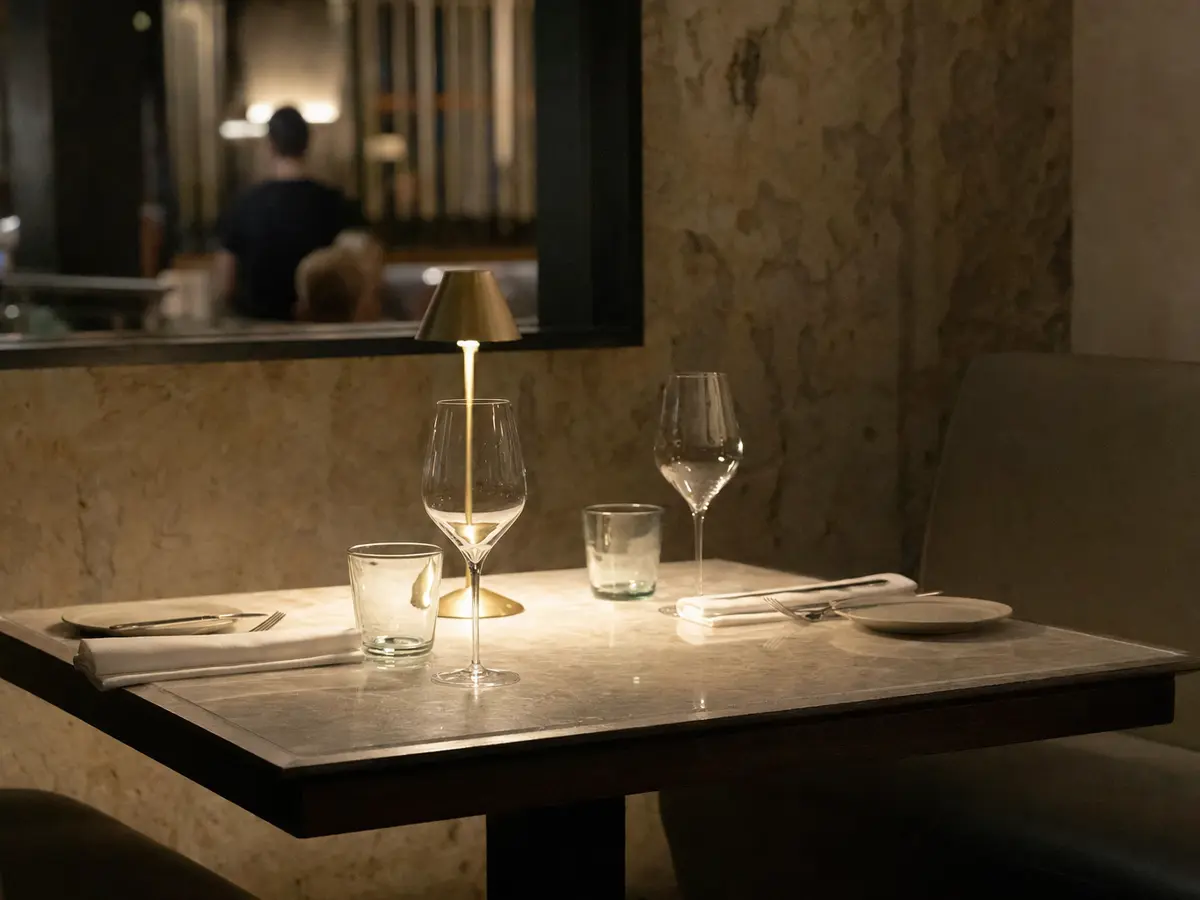 A quiet corner table set for two in a dimly lit restaurant