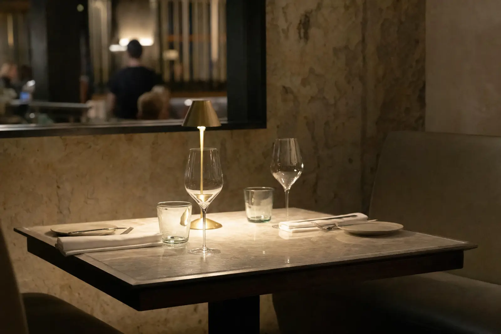 A quiet corner table set for two in a dimly lit restaurant