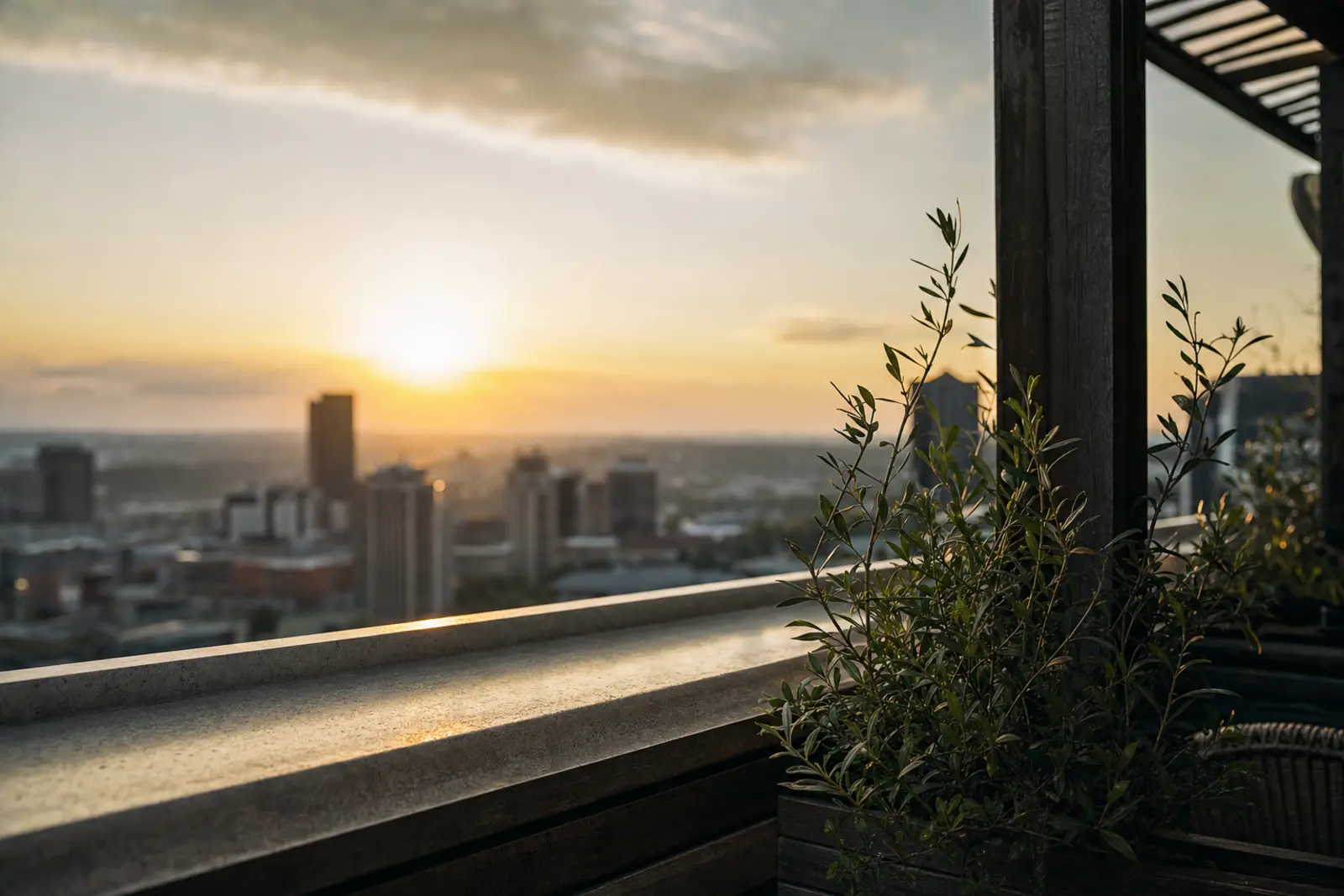 A rooftop terrace at sunset with the city skyline beyond