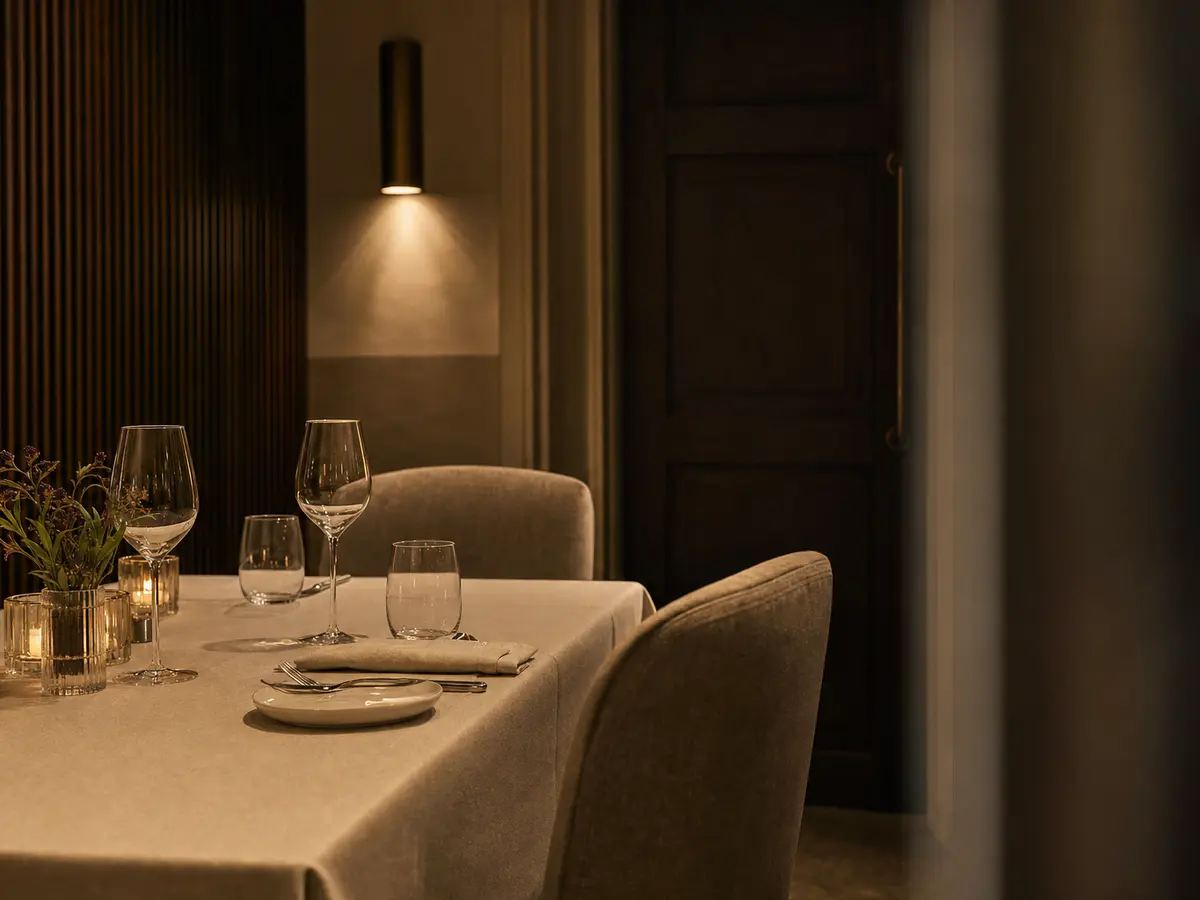 A small private dining room set for two, warm low light