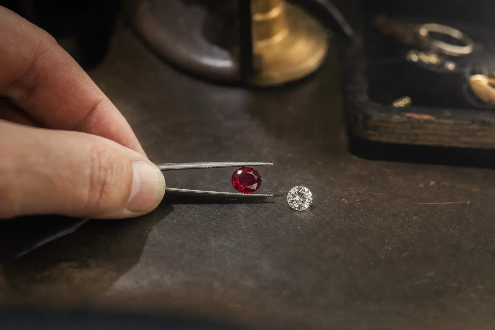 A loose ruby held to the light beside a diamond of similar size for comparison