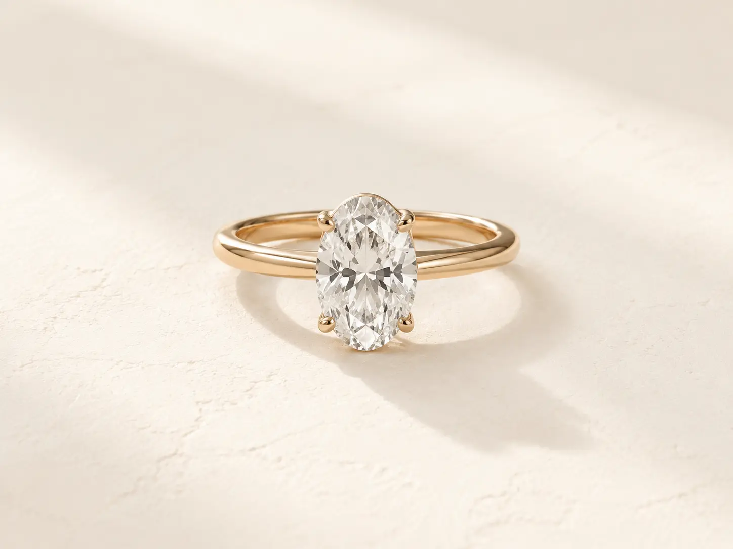 An oval diamond solitaire ring in yellow gold